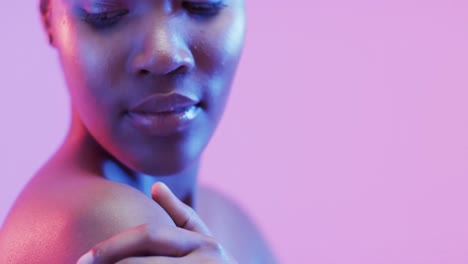 African-american-woman-with-short-dark-hair-in-blue-and-pink-light-with-copy-space,-slow-motion