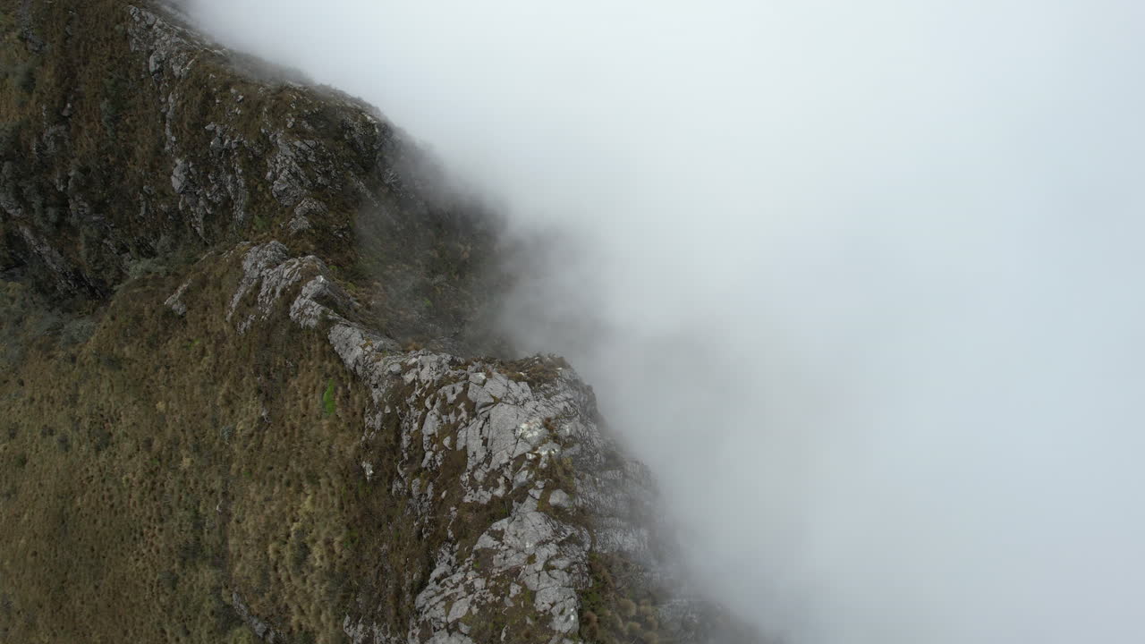 vista aérea de colinas empinadas y nubes densas bajo el volcán rucu pichincha ecuador - disparo de drones