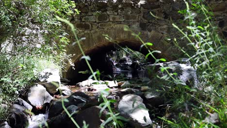 Toma-Estática-De-Agua-Que-Fluye-Lentamente-Bajo-Un-Puente-En-Las-Montañas-Troodos,-Chipre