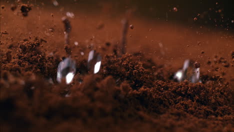 brewing ground coffee with boiling water droplets in macro and slow motion