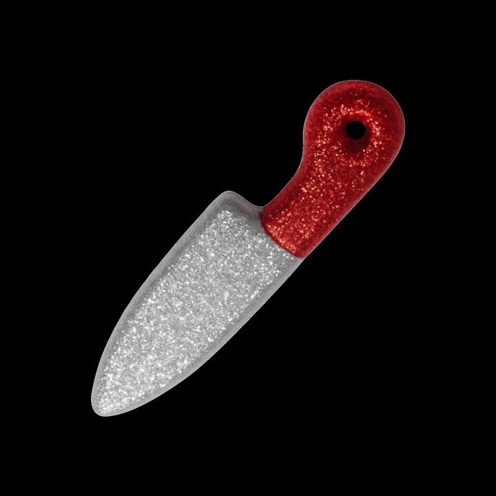Glittery Toy Knife Rotating Against a Black Background