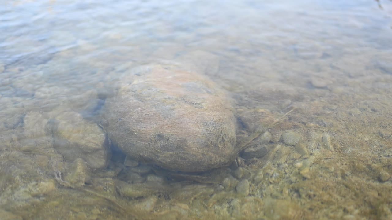 파키스탄 발로치스탄의 맑은 강 아래에는 수많은 자갈이 있는 크고 둥근 돌 또는 바위가 있습니다.