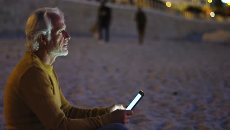 Hombre-Mayor-Usando-Tableta-Digital-En-La-Playa-4k