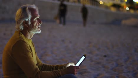 senior man using digital tablet on the beach 4k
