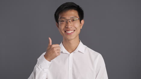 asian man smiling and doing ok gesture to the camera.