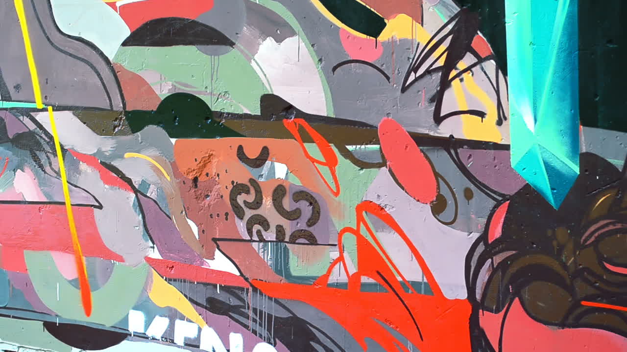 El artista dibuja grafitis en una valla. Grafiti en una valla.