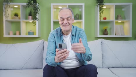 The-old-man-is-making-a-video-call-on-the-phone.