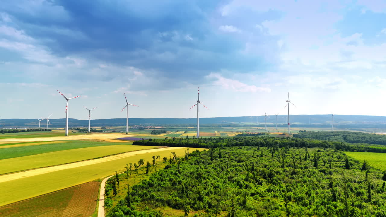 Wind farms set in the countryside produce green energy. Alternative power, renewable energy concept. Aerial view