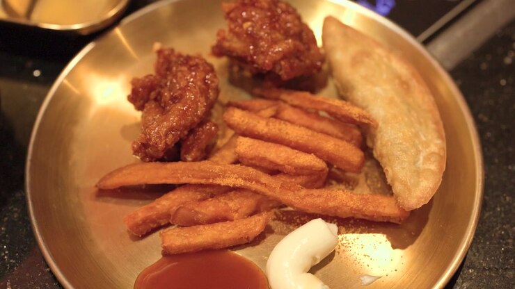 Korean Fried Chicken with Fries and Dumpling on a Brass Plate