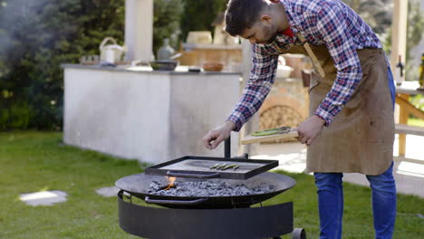 man grilling asparagus in backyard