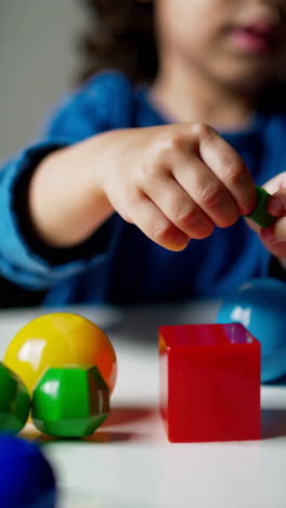child playing with colorful geometric learning toys