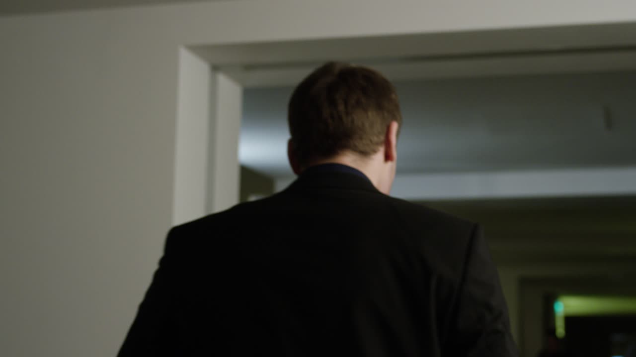 밤 에 사무실 복도 를 가로질러 고 있는 사업가