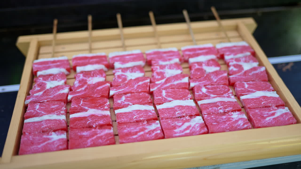 Close up of multiple pieces of Wagyu beef on a wooden tray at a street food market in Japan