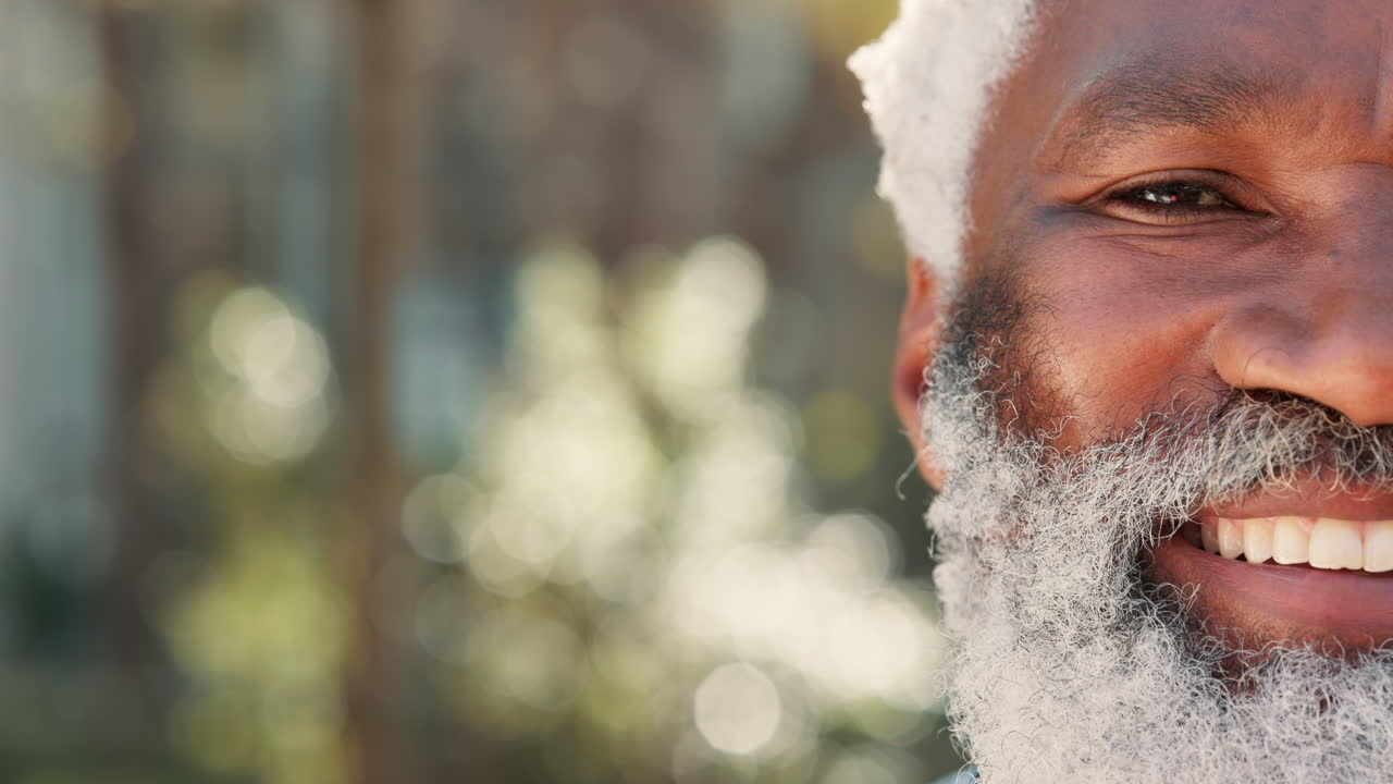 Close-up portrait of a smiling older man with a white beard