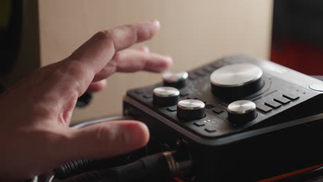 소리 서 (sound mixer) 를 조작하는 손의 클로즈업 (close-up of a hand operating a sound mixer, adjusting the knobs to fine-tune audio levels) 은 서의 컨트롤과 촉각적 상호 작용을 보여준다.
