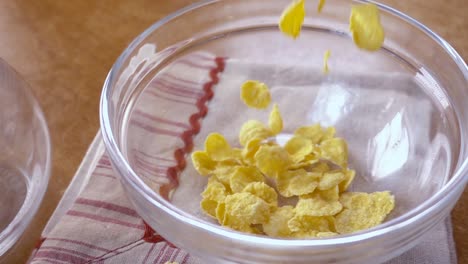 Crispy-yellow-corn-flakes-into-the-bowl-for-the-morning-a-delicious-Breakfast-with-milk.-Slow-motion-with-rotation-tracking-shot.