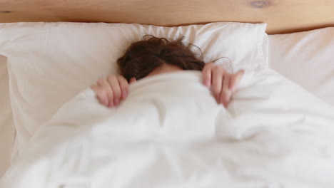 relaxing in bed, woman sleeping under white blanket in cozy bedroom