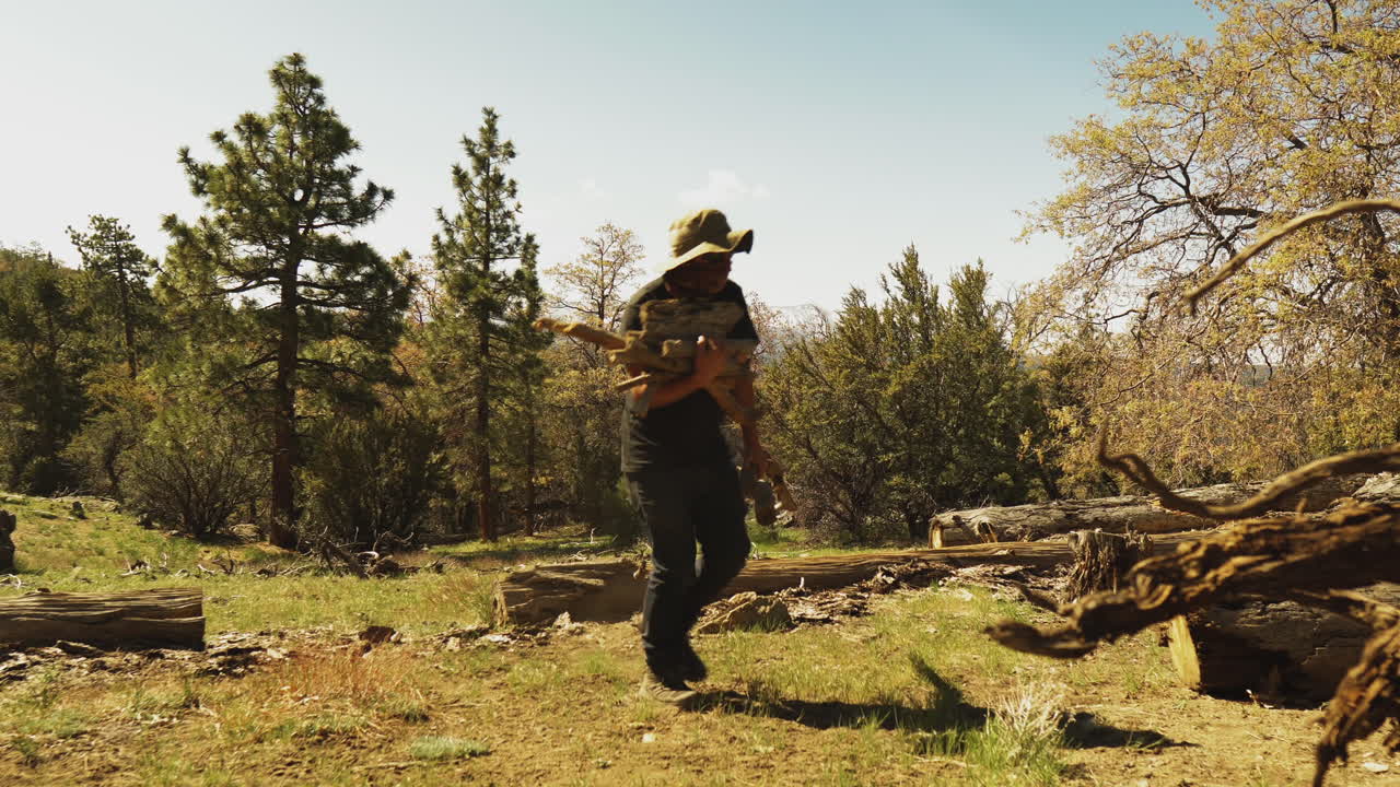 나무더미를 팔에 안고 있는 야영자는 큰 나뭇가지를 들고 틀 밖으로 걸어나간다