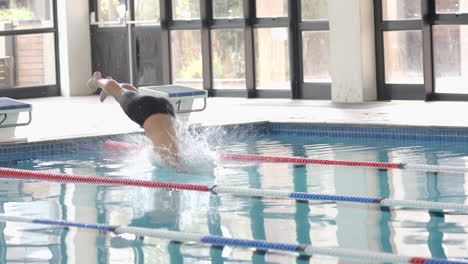 diving into swimming pool, male athlete practicing swimming in indoor pool, copy space