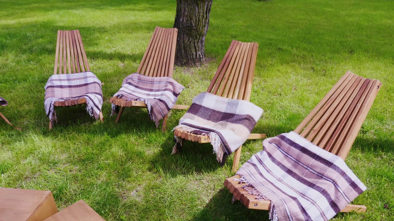 varias tumbonas de madera con alfombras en un césped verde un lugar para relajarse en el complejo video hd