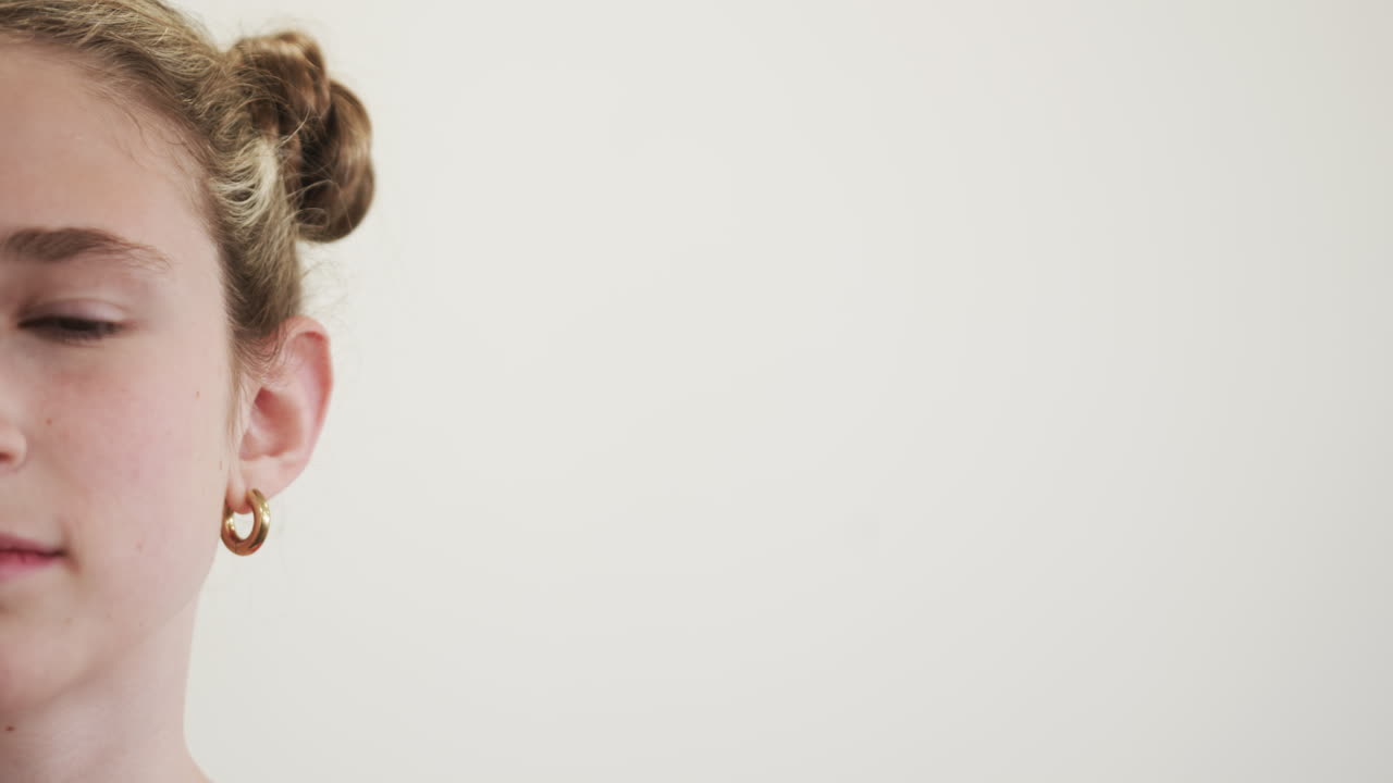 Close-up of young girl with earrings, focused and attentive in classroom, at school, copy space