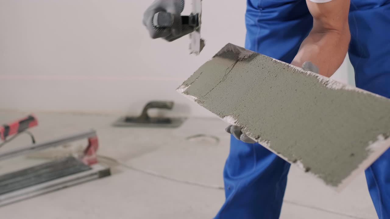 Construction, renovation, repair apartment. Installing ceramic floor tiles - measuring and cutting the pieces. Cuts tile. Tile cutting