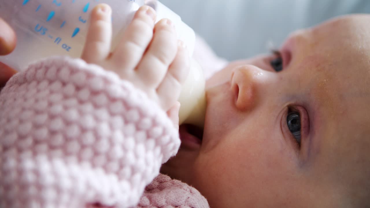 adorable niña siendo alimentada y bebiendo leche