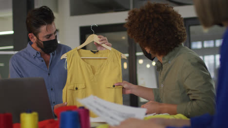 Mixed-race-clothes-designers-having-video-call-wearing-face-masks