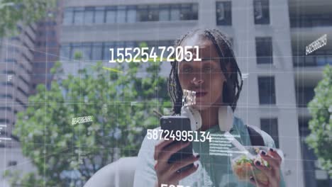Animation-of-data-processing-over-african-american-woman-with-a-snack-using-smartphone-on-the-street