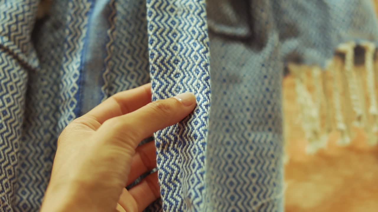 여자는 가게에서 옷감의 질감을 느낀다