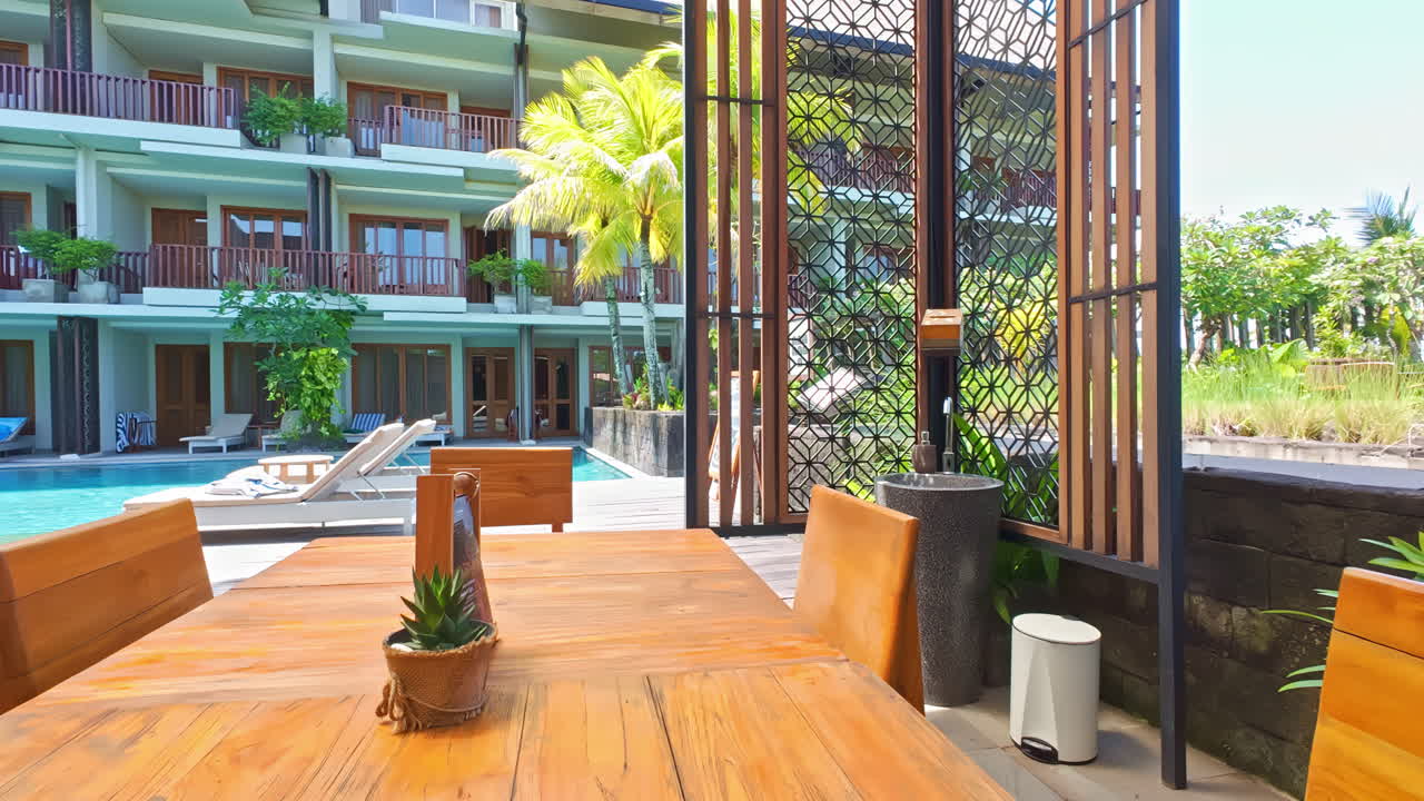 Cozy café in a wooden resort with stunning views of palm trees and a clear pool