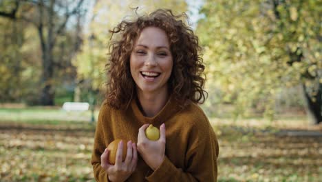 caucasian woman with oranges and lemon at the autumn park.