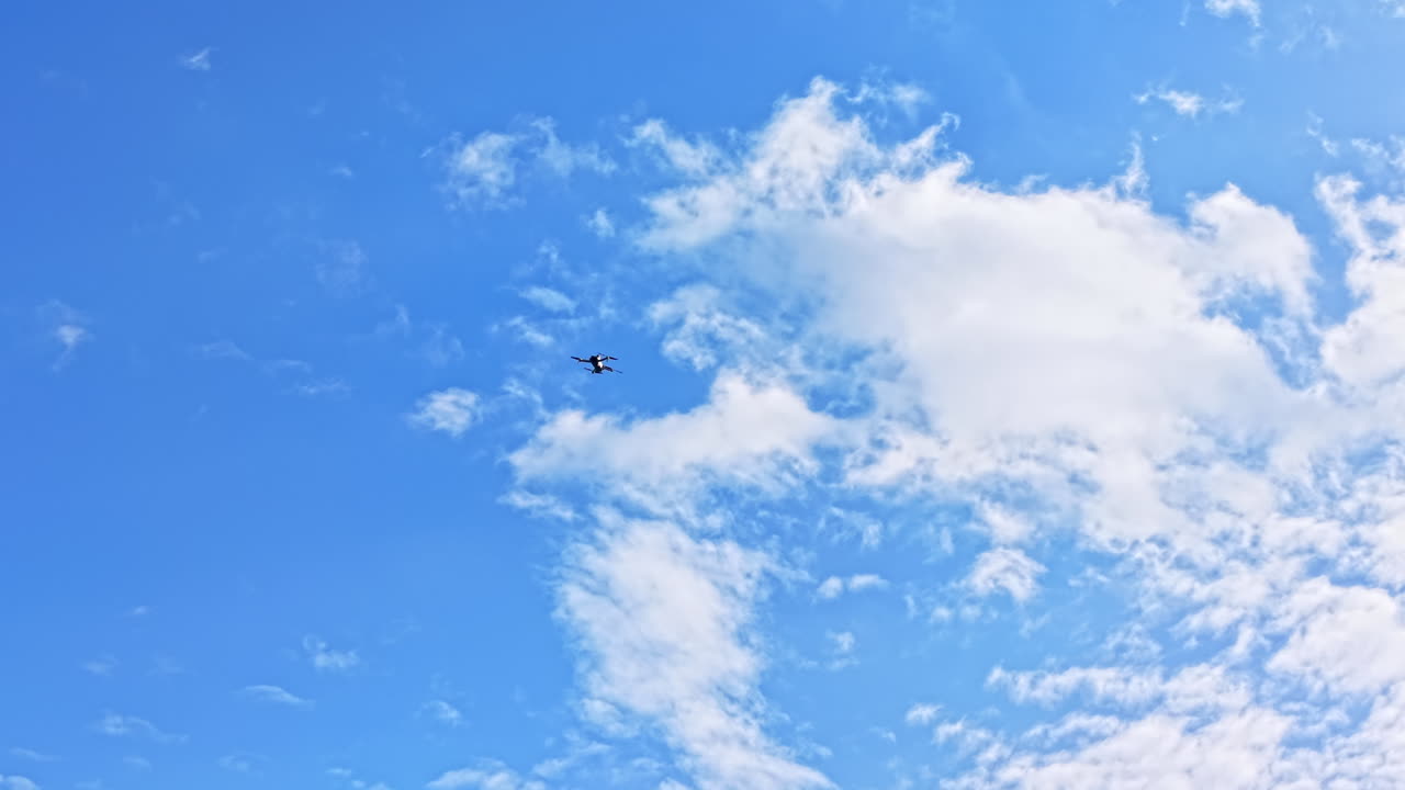 Flyvemaskine flyver på en blå himmel med skyer om dagen over bylandskabet