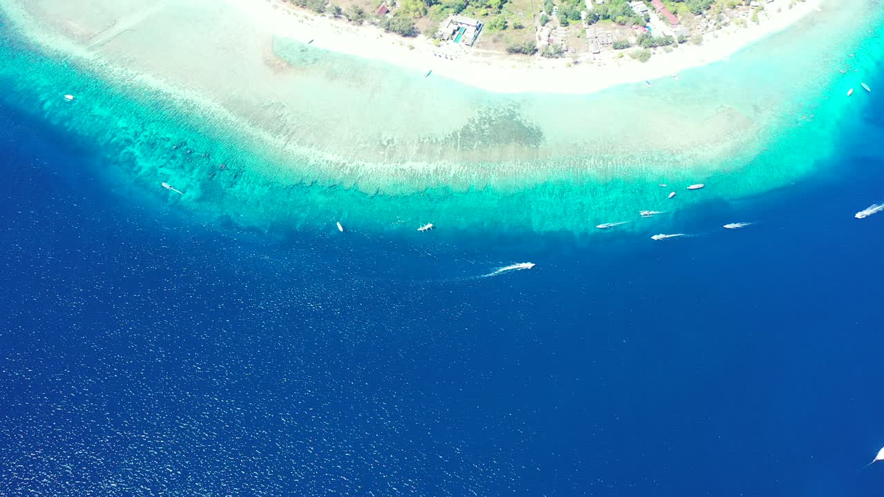 Vibrant aqua and blue waters glistening from the sunlight off the coastline of a paradise island