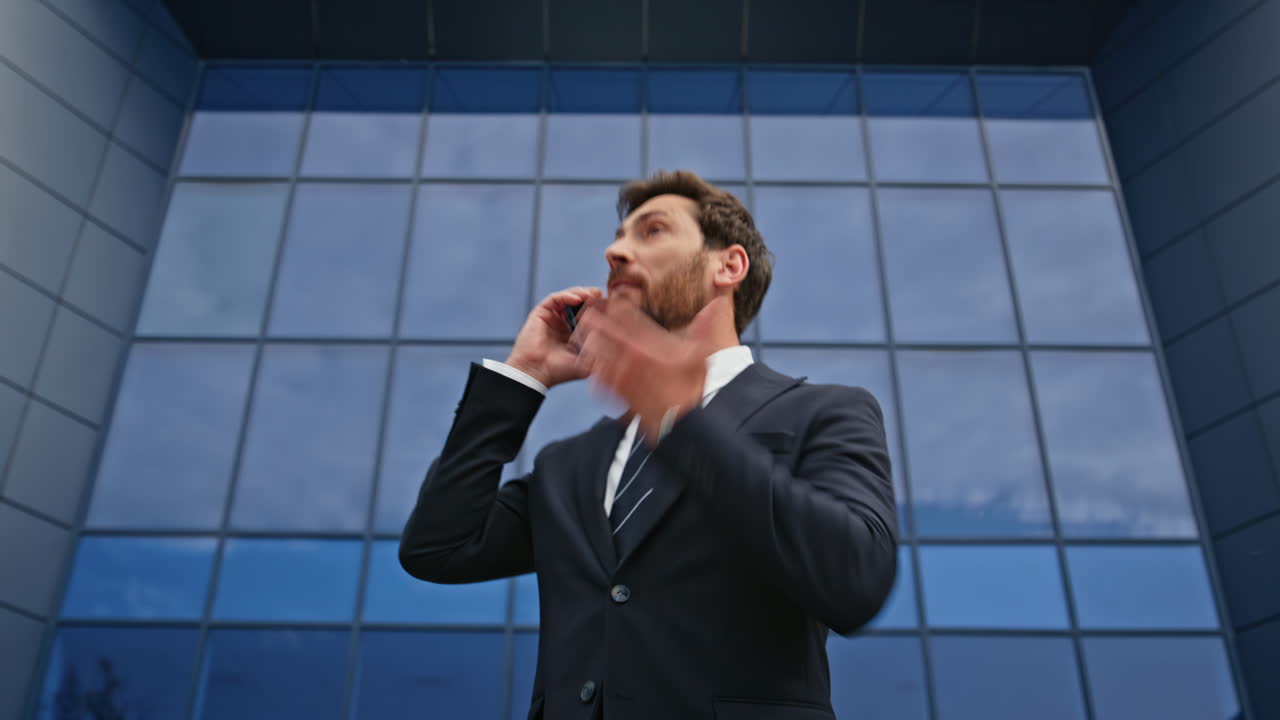 Mad ceo yelling mobile phone emotionally gesturing outside glass office closeup
