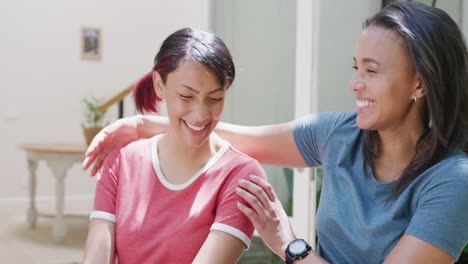 Happy-biracial-sisters-embracing-and-smiling-in-garden,-in-slow-motion