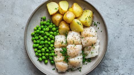 healthy plate of fish, potatoes, and green peas dish