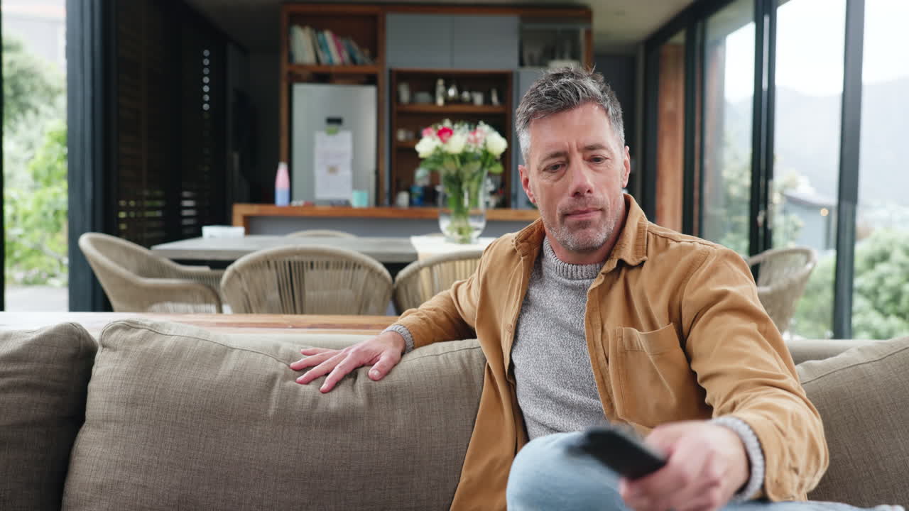 Glad par slapper af på sofaen og ser tv sammen
