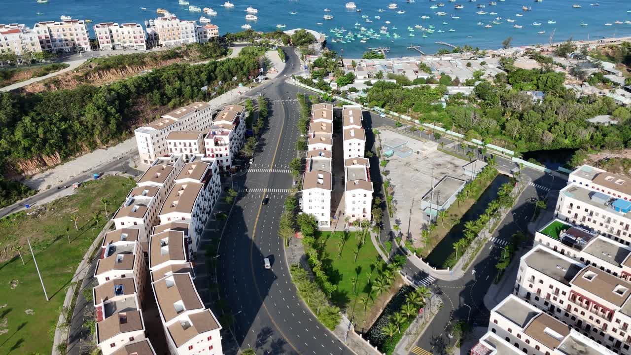 An aerial view of a modern city that connects with the main road. Mediterranean architecture style of apartments and buildings.Shimmering waters dotted with a variety of boats and elegant yachts.