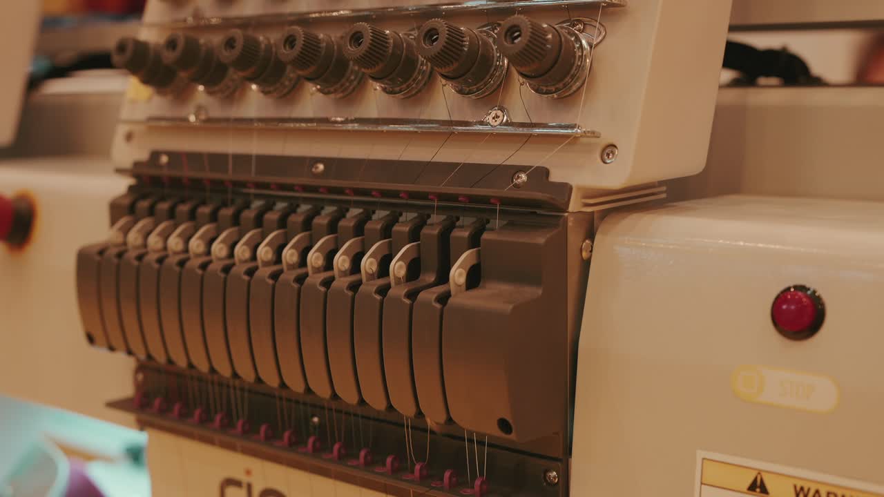 detailed view of embroidery machine thread spools and tension controls