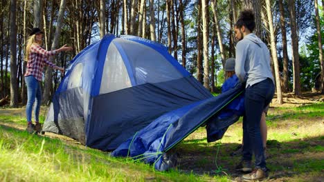 friends setting up tent in the forest on a sunny day 4k