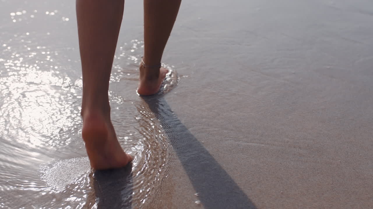 pies de mujer caminando descalzos en la playa disfrutando de la suave arena del mar húmedo turista femenina en vacaciones de verano
