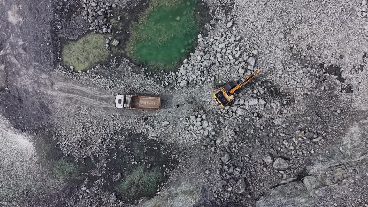Vista aerea di escavatore che carica un dumper in cava