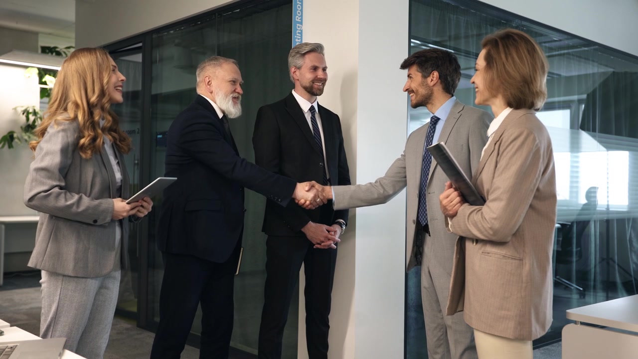 Professionisti d'affari si stringono la mano e discutono in un ufficio moderno