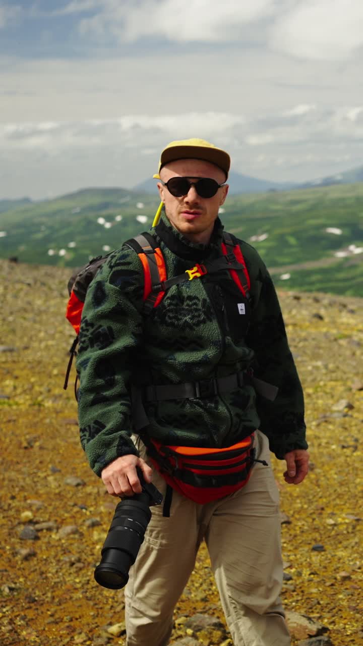 Adventurous Man Hiker with Camera Walking on Rocky Mountain