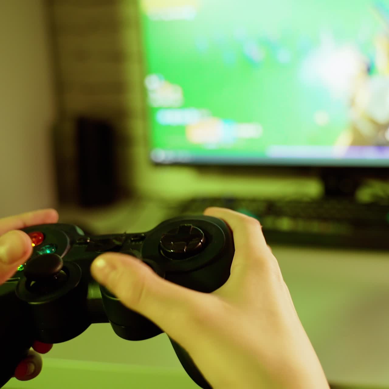Boy uses joystick to play video game on Play Station. The console in gamer's hands during game time in front of the screen. Close-up.