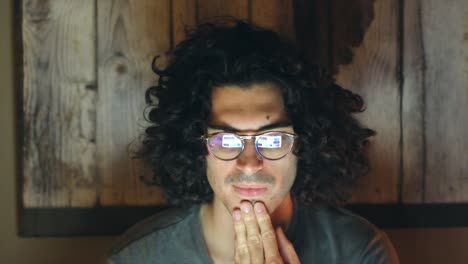joven trabajando con una computadora portátil y revisando correos electrónicos en una habitación oscura
