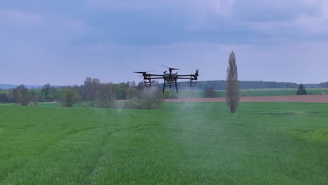 professional agriculture drone flying and spraying fertilizer over green farming field