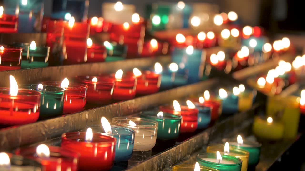 Candele colorate che bruciano in chiesa, simbolismo delle preghiere religiose