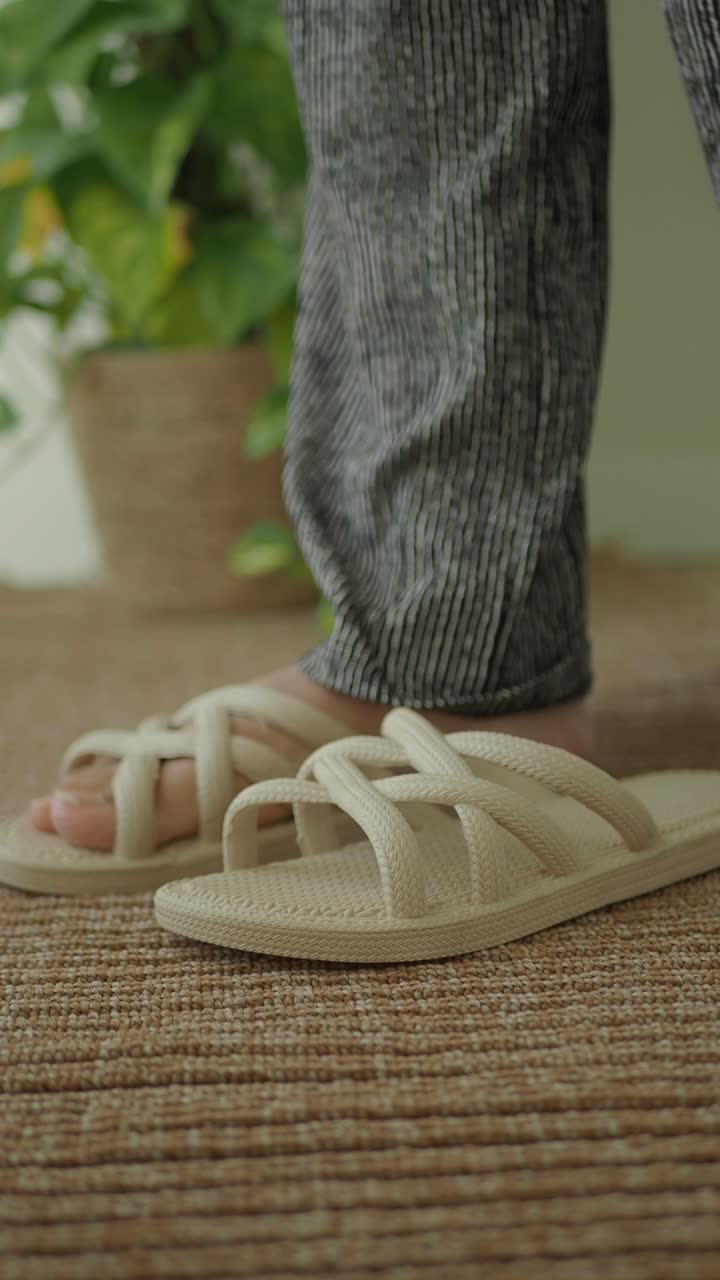 Primo piano di un piede che entra in sandali beige